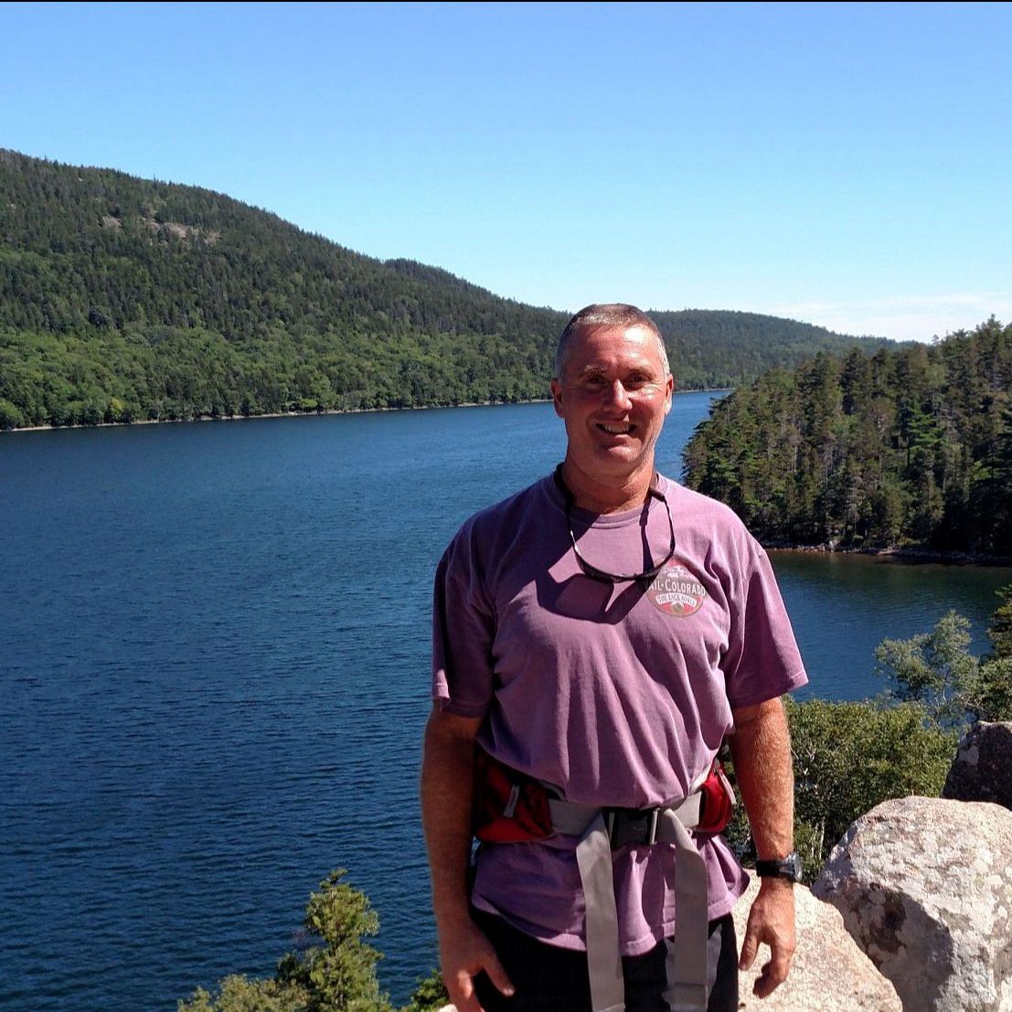 Man posing on mountain with lake view