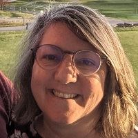 A smiling woman wearing glasses.