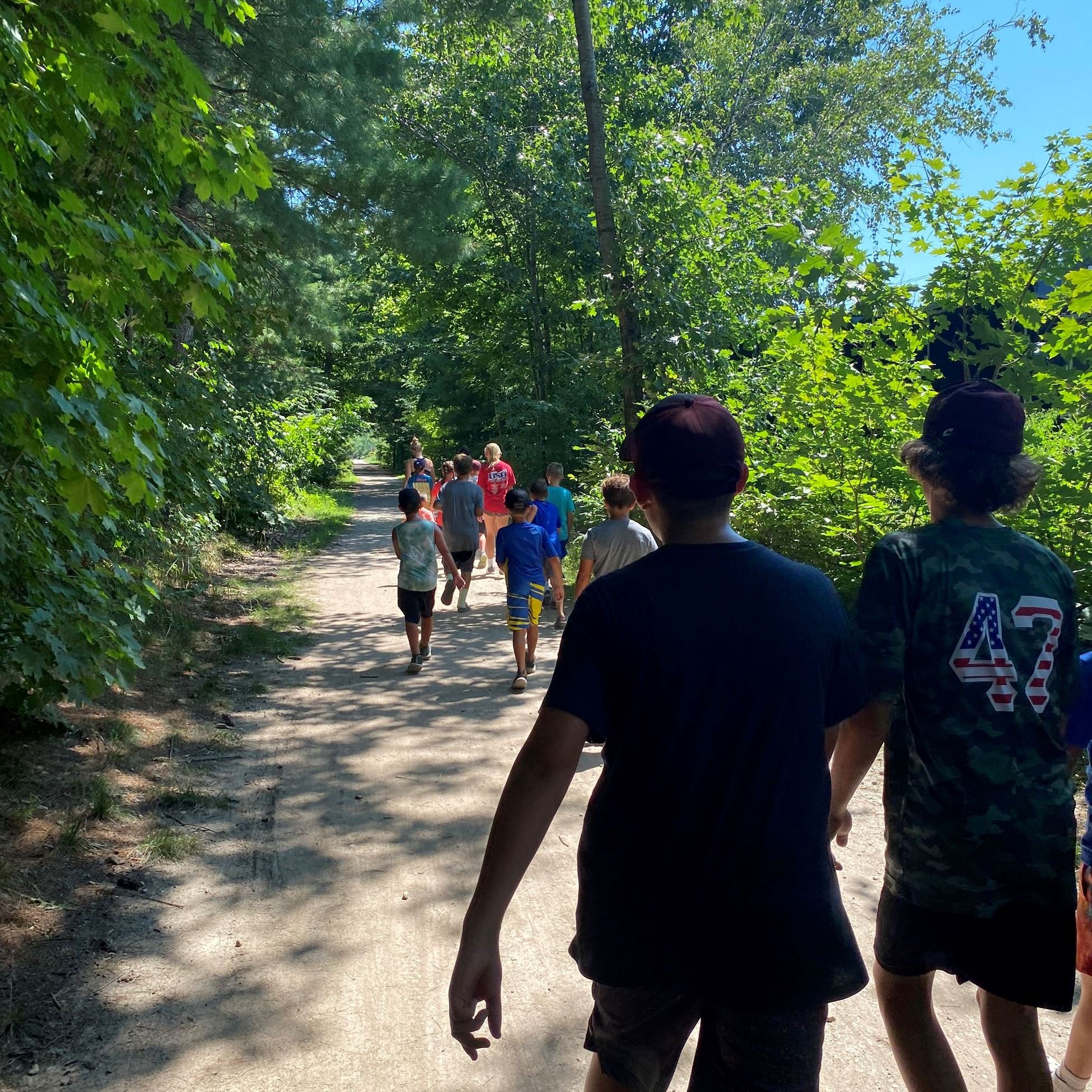group of kids walking on nature trail